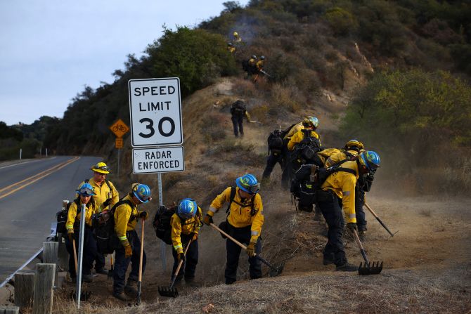 Firefighters cut a line as they battle the Franklin Fire in Malibu, California, on Wednesday, December 11.