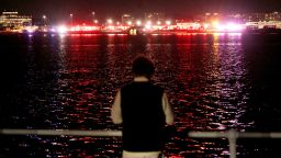 A person looks on from the bank of the Potomac River as emergency service vehicles operate near the site of the crash after American Eagle flight 5342 collided with a helicopter while approaching Ronald Reagan Washington National Airport and crashed in the Potomac River, outside Washington, U.S., January 29, 2025. REUTERS/Carlos Barria 