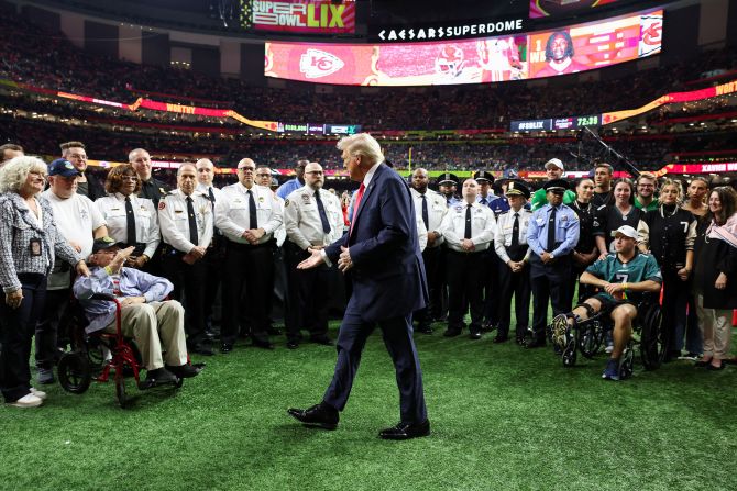 Trump greets people taking part in an honorary coin toss.