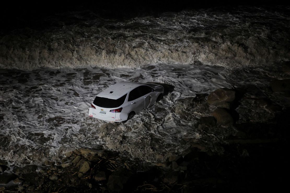 A firefighter's car sits in the ocean, after being washed away in a mudslide off the Pacific Coast Highway in Malibu, California, on Thursday.