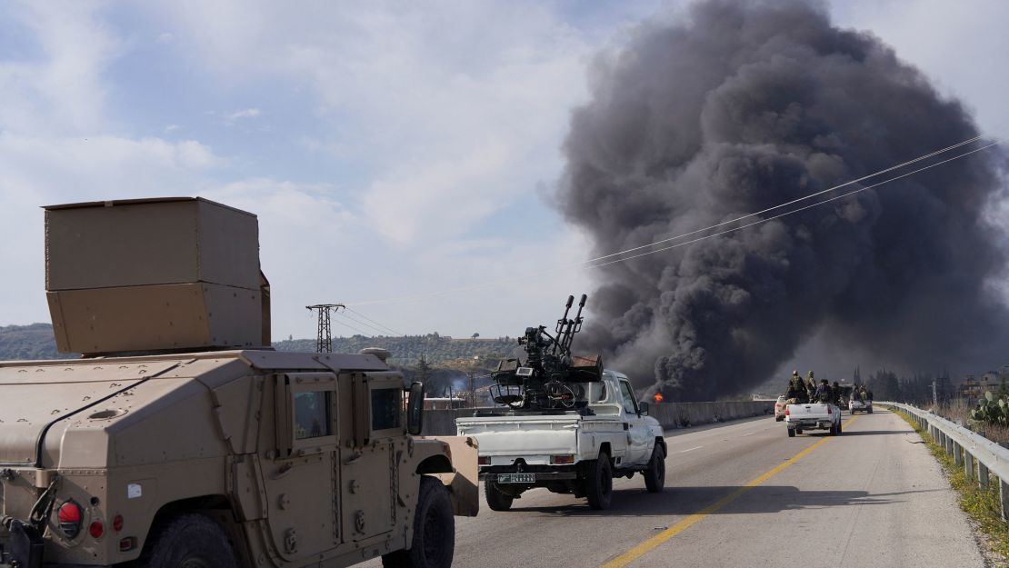 Syrian forces drive toward rising smoke in Latakia on Friday.