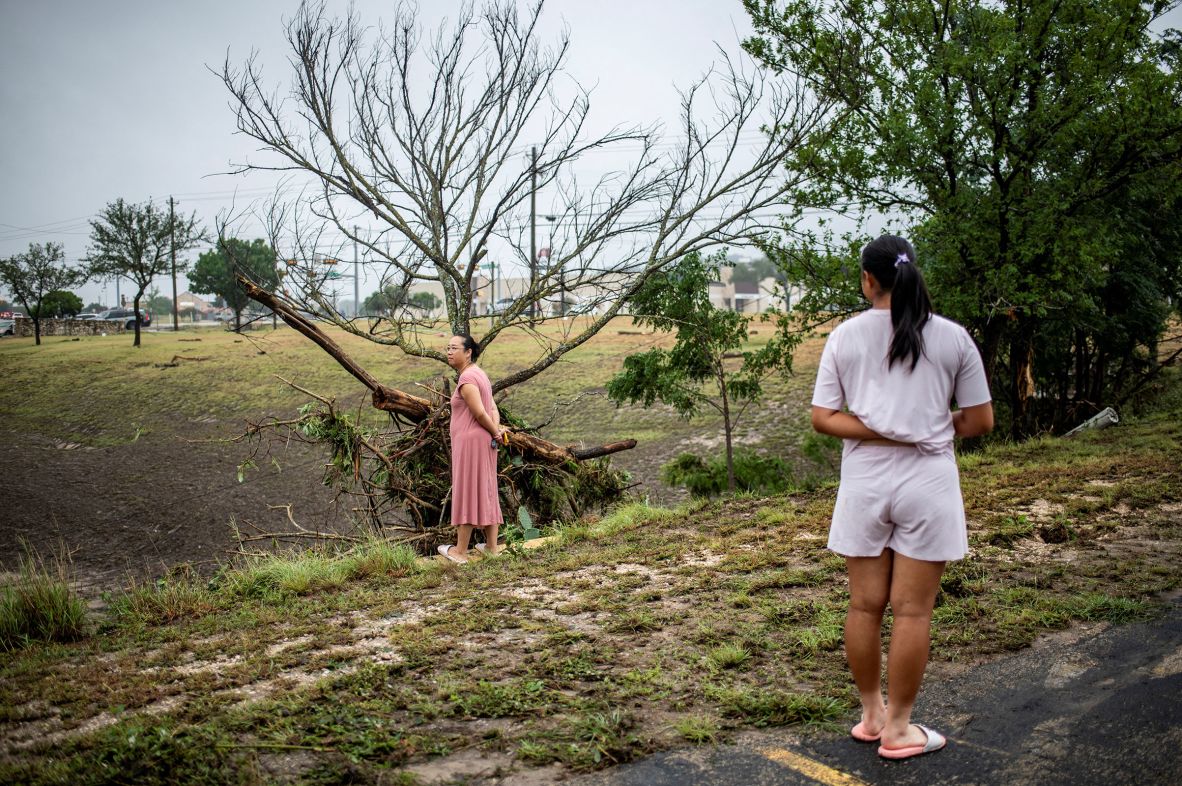 Ruby Zhu looks at her mother, Zhou, as she inspects damage in Kerrville on Saturday.
