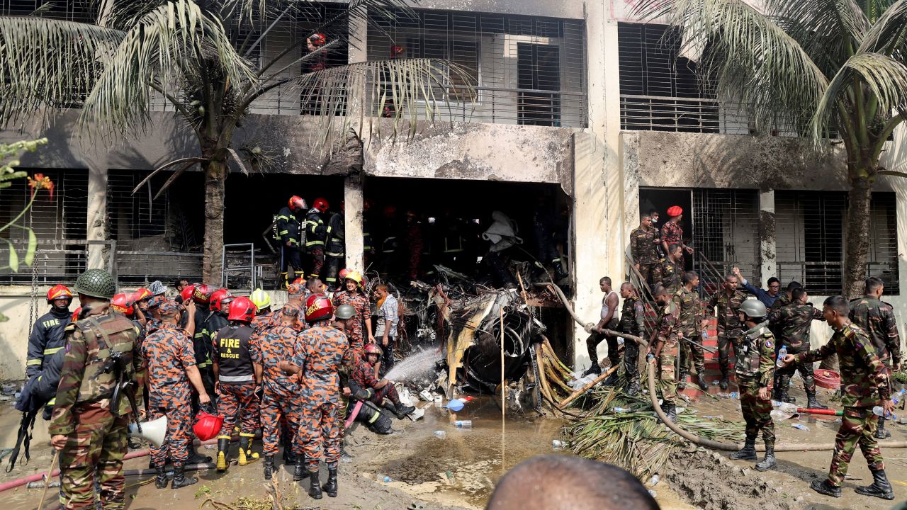 Firefighters and soldiers work next to the wreckage of an air force training aircraft after it crashed into Milestone College campus, in Dhaka, Bangladesh, July 21, 2025. REUTERS/Stringer