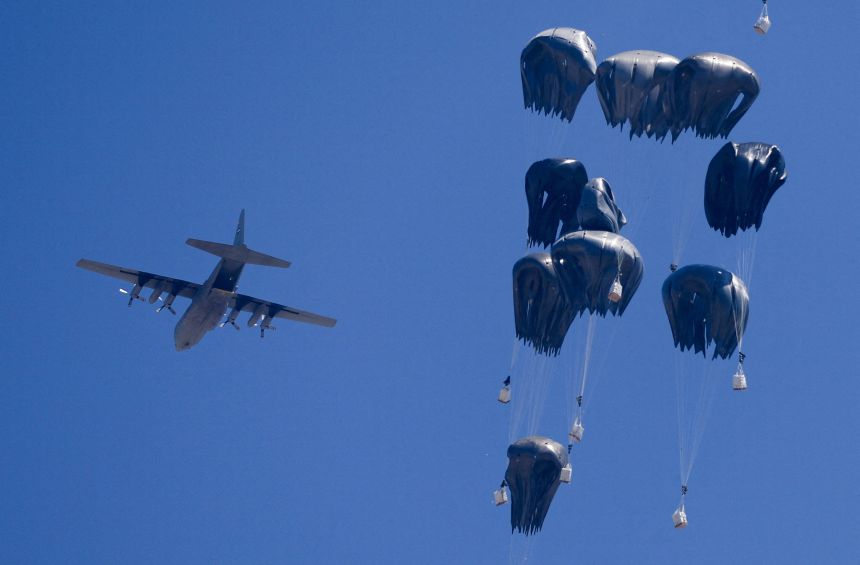An airplane drops humanitarian aid over Gaza as seen from northern Gaza Strip on Sunday.