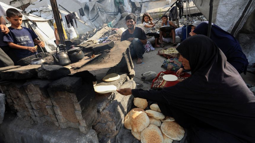 A displaced Palestinian family bakes bread at a tent camp where they shelter, as the Israeli military prepares to relocate residents to southern Gaza, in Gaza City, August 18, 2025. REUTERS/Dawoud Abu Alkas
