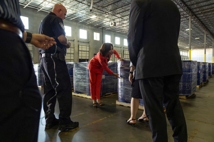 US Attorney Jeanine Pirro points towards labels on containers, holding what a Department of Justice media advisory described as 