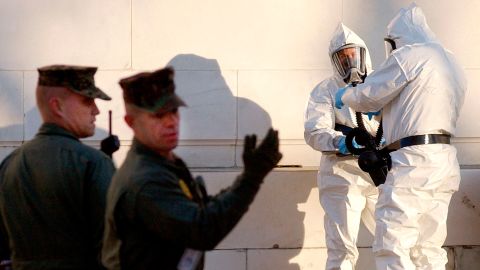 U.S. Marines control the area as unidentified civilians dressed in protective suits prepare to enter the closed Russell Senate Office Building on Capitol Hill, to retreive mail that could be contaminated, February 4, 2004. Two days after the discovery of ricin in the mailroom of Senate Majority Leader Bill Frist, three Senate office buildings remained closed on Wednesday, displacing thousands of workers and raising echoes of a 2001 anthrax attack on the Capitol. No more ricin has so far been detected in the Capitol complex and no one is showing any signs of poisoning. REUTERS/Jonathan Ernst  LSD/GN