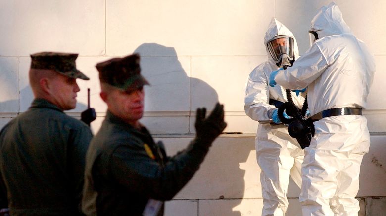 U.S. Marines control the area as unidentified civilians dressed in protective suits prepare to enter the closed Russell Senate Office Building on Capitol Hill, to retreive mail that could be contaminated, February 4, 2004. Two days after the discovery of ricin in the mailroom of Senate Majority Leader Bill Frist, three Senate office buildings remained closed on Wednesday, displacing thousands of workers and raising echoes of a 2001 anthrax attack on the Capitol. No more ricin has so far been detected in the Capitol complex and no one is showing any signs of poisoning. REUTERS/Jonathan Ernst  LSD/GN