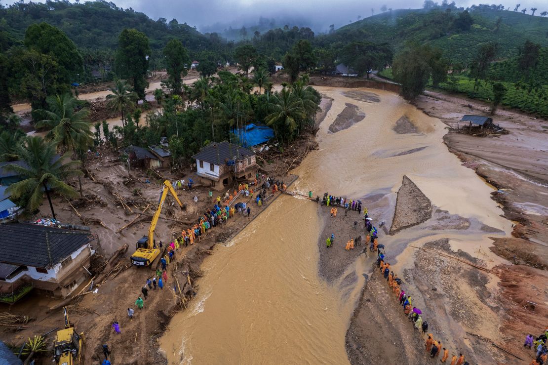 Rescuers cross a river at Chooralmala, Kerala state, on Wednesday.