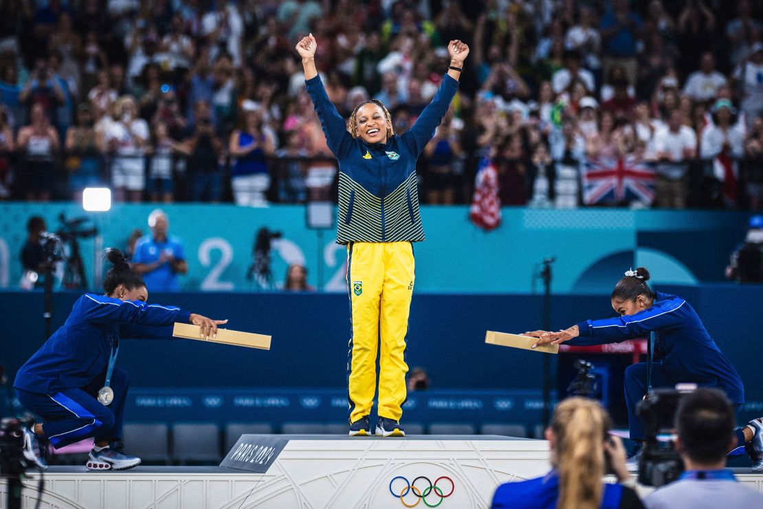 Az amerikai Simone Biles, a brazil Rebecca Andrade és az amerikai Jordan Chiles ünnepel az érmek átadása közben a párizsi olimpia női művészi gimnasztika döntője után.