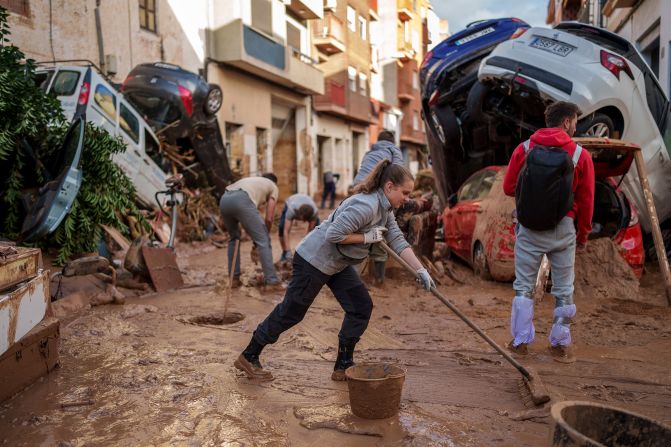 People clean a street in Valencia on Saturday.