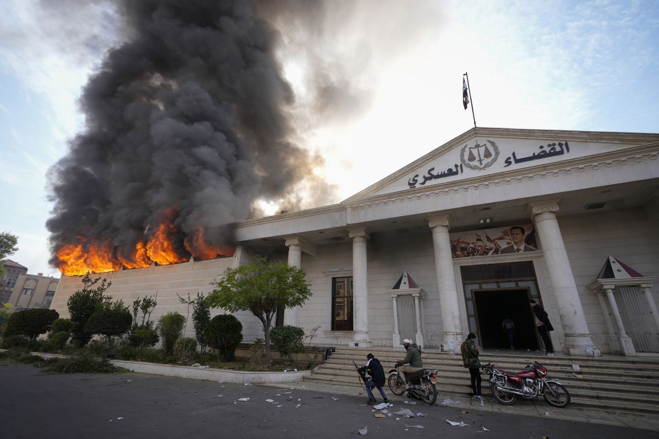 Opposition fighters burn a military court in Damascus, Syria, on December 8.