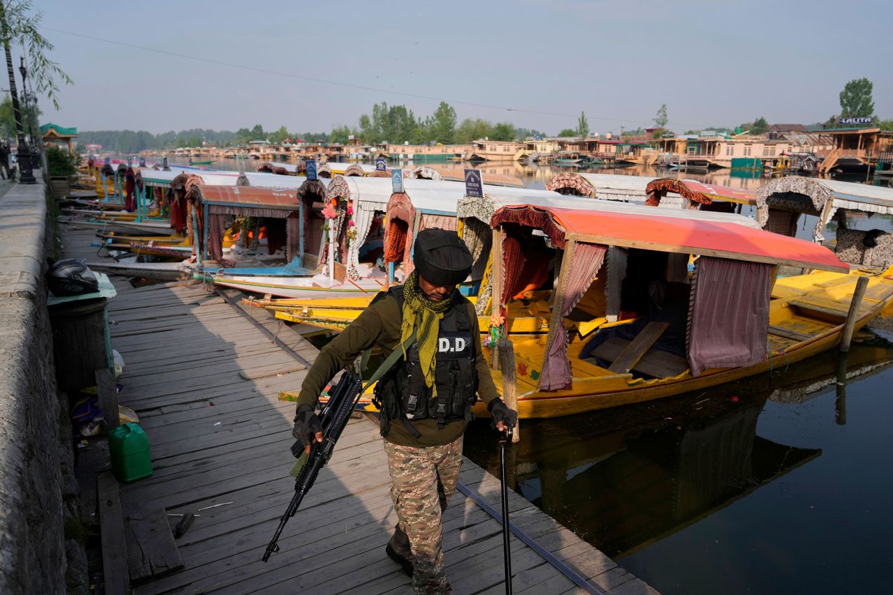 An Indian soldier patrols near parked boats at Dal Lake in Srinagar, Indian-administered Kashmir, on Wednesday.