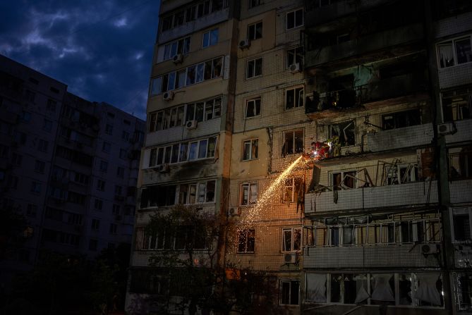 A firefighter clears debris from a residential building that was damaged by a Russian attack in Kyiv, Ukraine, on Saturday, May 24.