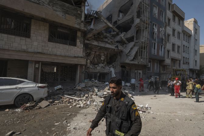 A police officer walks past a destroyed residential building after Israeli strikes in Tehran on Friday.