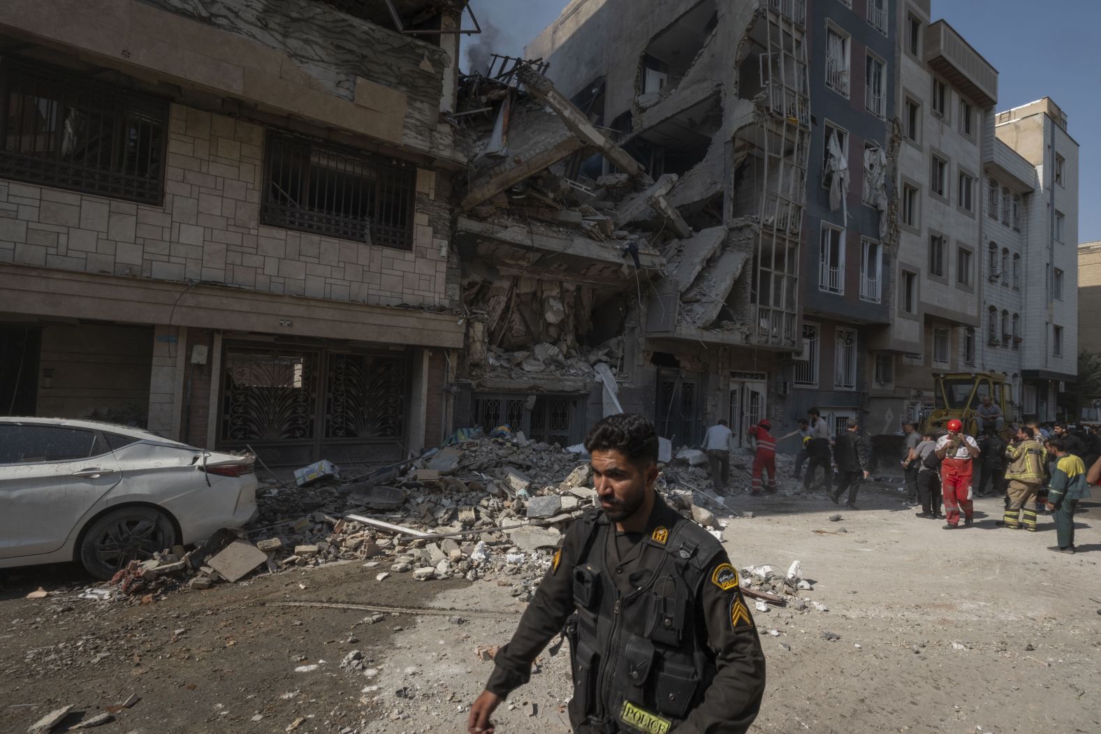 A police officer walks past a destroyed residential building after Israeli strikes in Tehran on Friday.