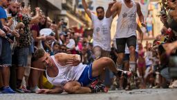 A participant falls wearing shoes with heels of at least 15 centimeters (5.9 inches) as they compete in the annual high heel race during Madrid's Pride week in Madrid, Spain, Thursday, July 3, 2025. (AP Photo/Manu Fernandez)