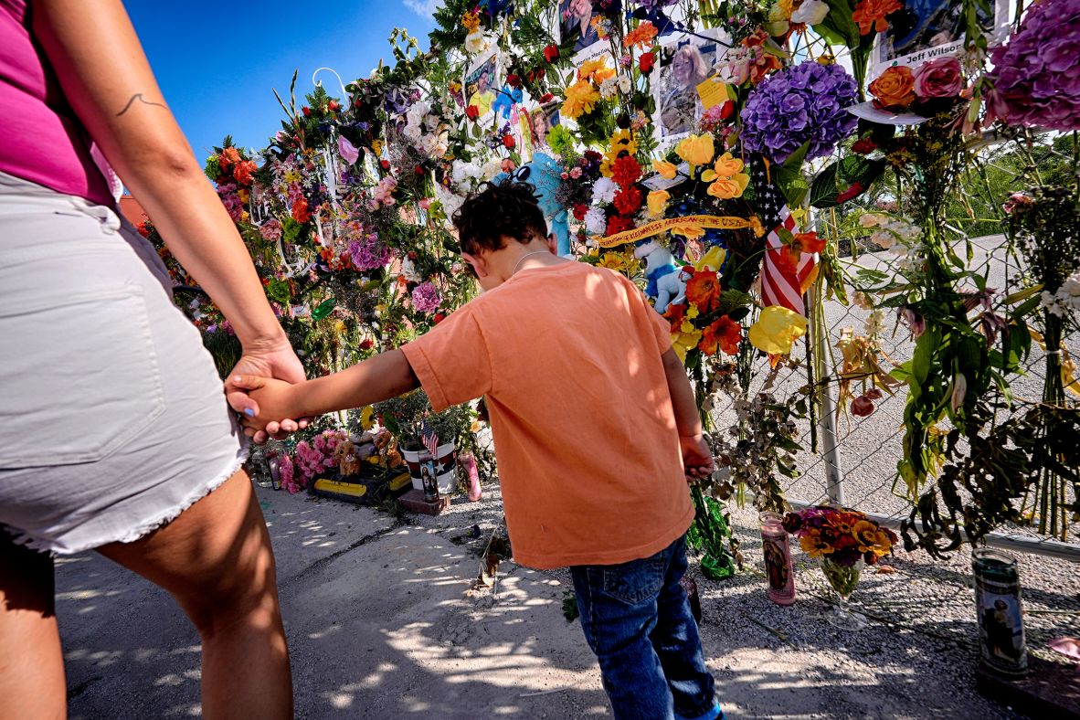Danielle Alonzo walks with her son Krew at a memorial wall for flood victims in Kerrville, Texas, on Friday, July 11.