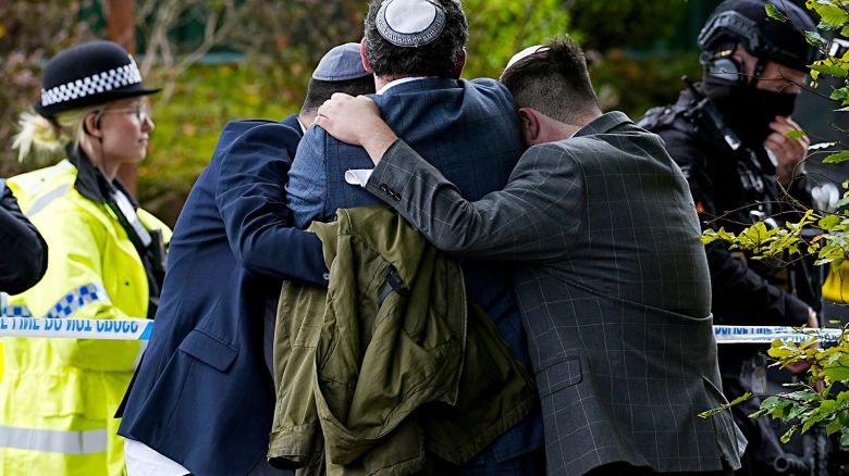 Members of the Jewish community comfort each other near the Heaton Park Hebrew Congregation synagogue in Crumpsall in Manchester, England, after an attacker killed two people at the synagogue on Thursday.