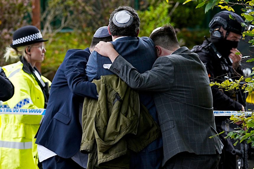 Members of the Jewish community comfort each other near to the Heaton Park Hebrew Congregation synagogue, in Crumpsall, Manchester, England, on October 2, 2025.