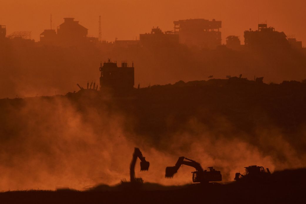 Israeli excavators operate in the Gaza Strip, as seen from southern Israel, on October 14, 2025.