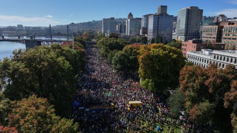 People gather along a waterfront park during a "No Kings" protest in Portland, Ore., on Saturday, Oct. 18, 2025. (AP Photo/Jenny Kane)
