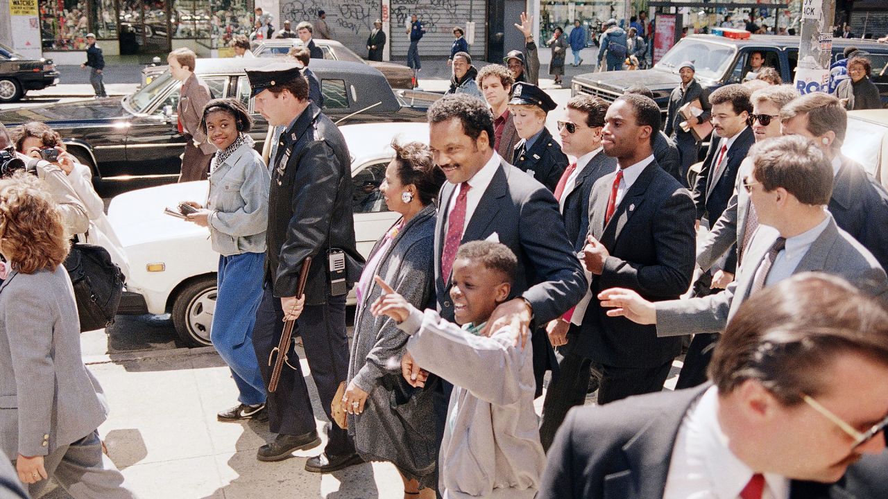 Democratic presidential candidate Jesse Jackson, center, with supporters and police walks to Sylvia’s Restaurant in the Harlem section of New York, Sunday, April 10, 1988. Jackson had just finished giving a sermon at the Abyssinian Baptist Church, also in the Harlem area. (AP Photo/Ron Edmonds)