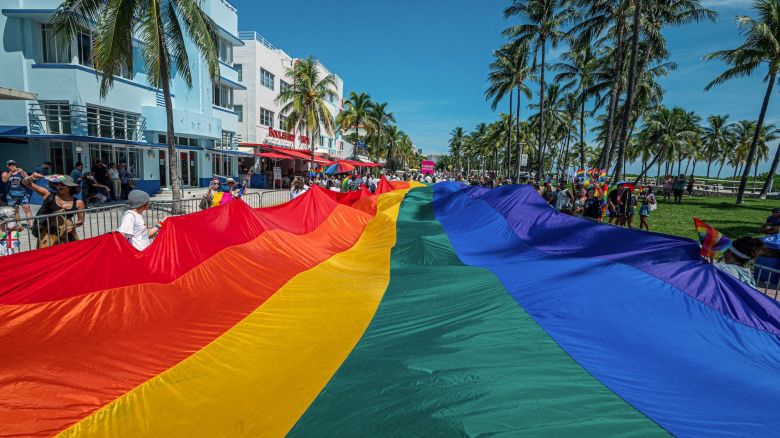 A huge multi-colored flag flies over Ocean Drive as people participate in the Pride Parade, during the Miami Beach Pride Festival, in Lummus Park, South Beach, Florida on September 19, 2021. (Photo by Giorgio Viera / AFP) (Photo by GIORGIO VIERA/AFP via Getty Images)