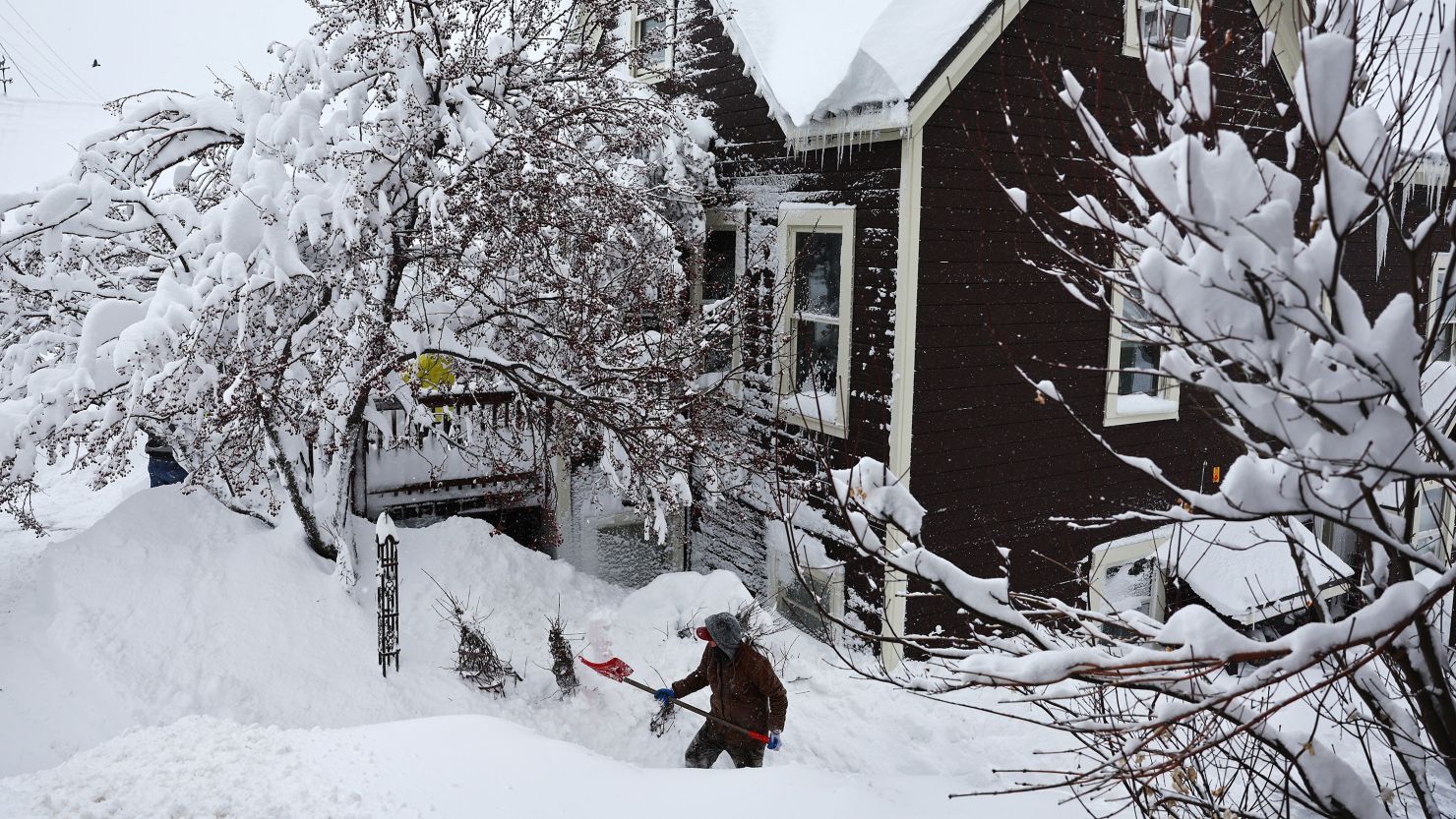 A worker digs out snow from a home north of Lake Tahoe during a powerful, multiple-day winter storm in the Sierra Nevada on March 02, 2024 in Truckee, California.