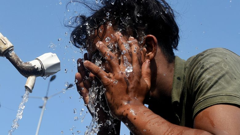 A worker is applying water to his face during the ongoing heatwave in Mumbai, India, on April 22, 2024. (Photo by Indranil Aditya/NurPhoto via Getty Images)