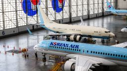 A worker (bottom L) stands below a Korean Air Airbus A220-200 in the maintenance hangar during a media tour of the Korean Air headquarters in Seoul on June 27, 2024.