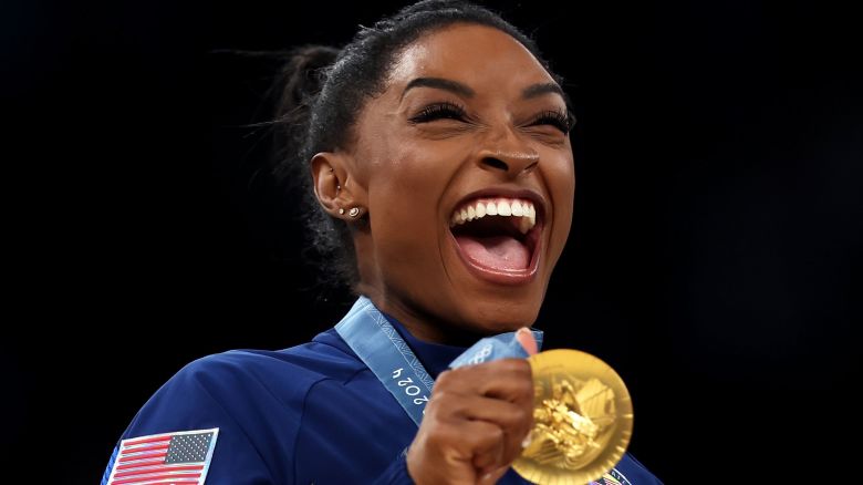 PARIS, FRANCE - JULY 30: Gold medalist Simone Biles of Team United States celebrates on the podium during the medal ceremony for the Artistic Gymnastics Women's Team Final on day four of the Olympic Games Paris 2024 at Bercy Arena on July 30, 2024 in Paris, France. (Photo by Naomi Baker/Getty Images)