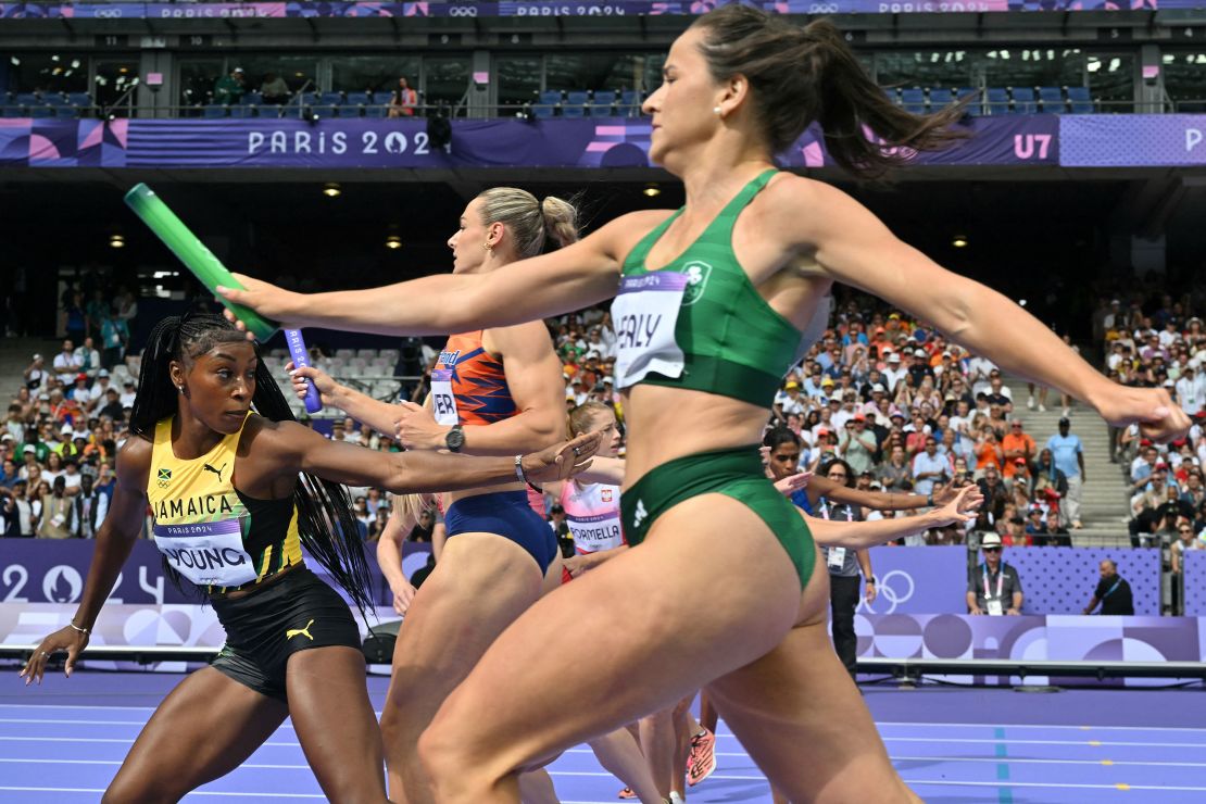 Jamaica's Charokee Young prepares for the baton exchange in the women's 4x400m relay heat of the athletics event at the Paris 2024 Olympic Games.