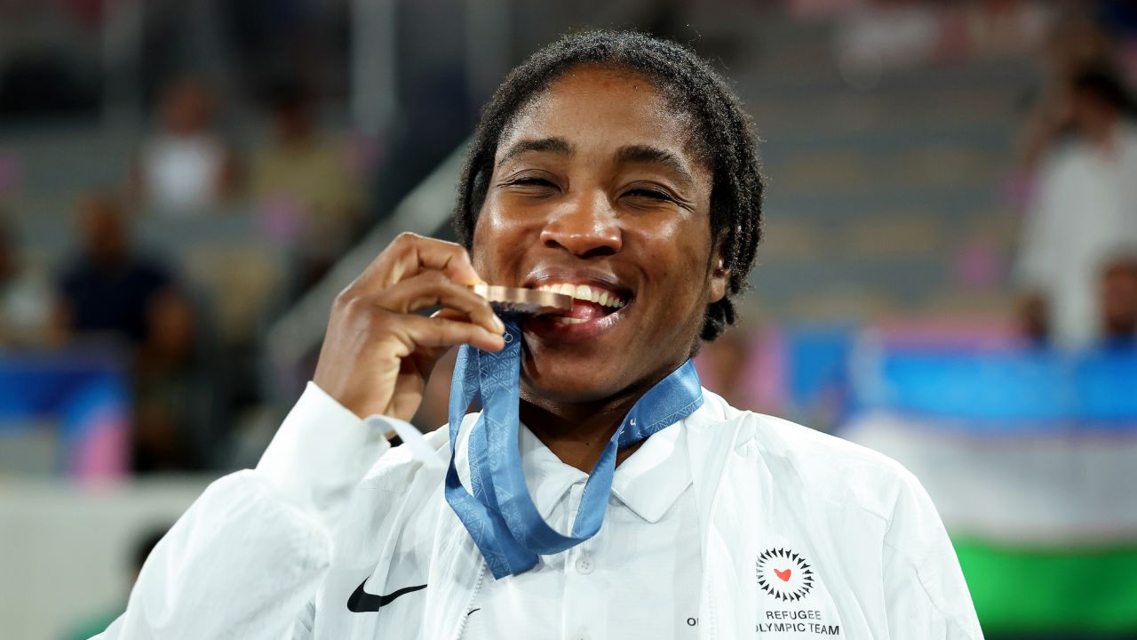 PARIS, FRANCE - AUGUST 10: Bronze Medallist Cindy Winner Djankeu Ngamba of Refugee Olympic Team bites her medal during the Boxing Women's 75kg medal ceremony after the Boxing Women's 75kg Final match on day fifteen of the Olympic Games Paris 2024 at Roland Garros on August 10, 2024 in Paris, France. (Photo by Richard Pelham/Getty Images)