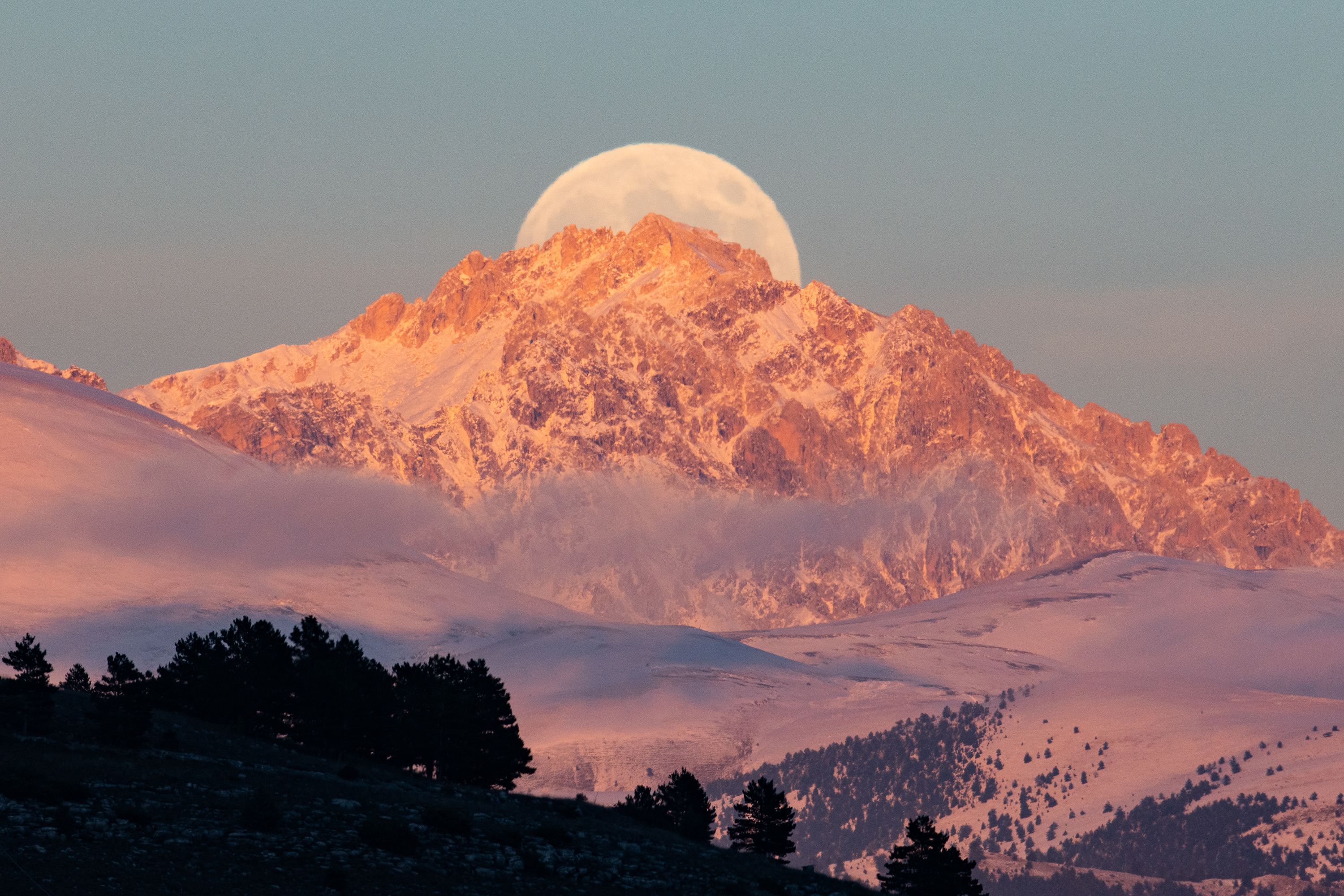 The beaver moon rises behind the Monte Prena peaks, seen from L'Aquila, Italy, on Friday.