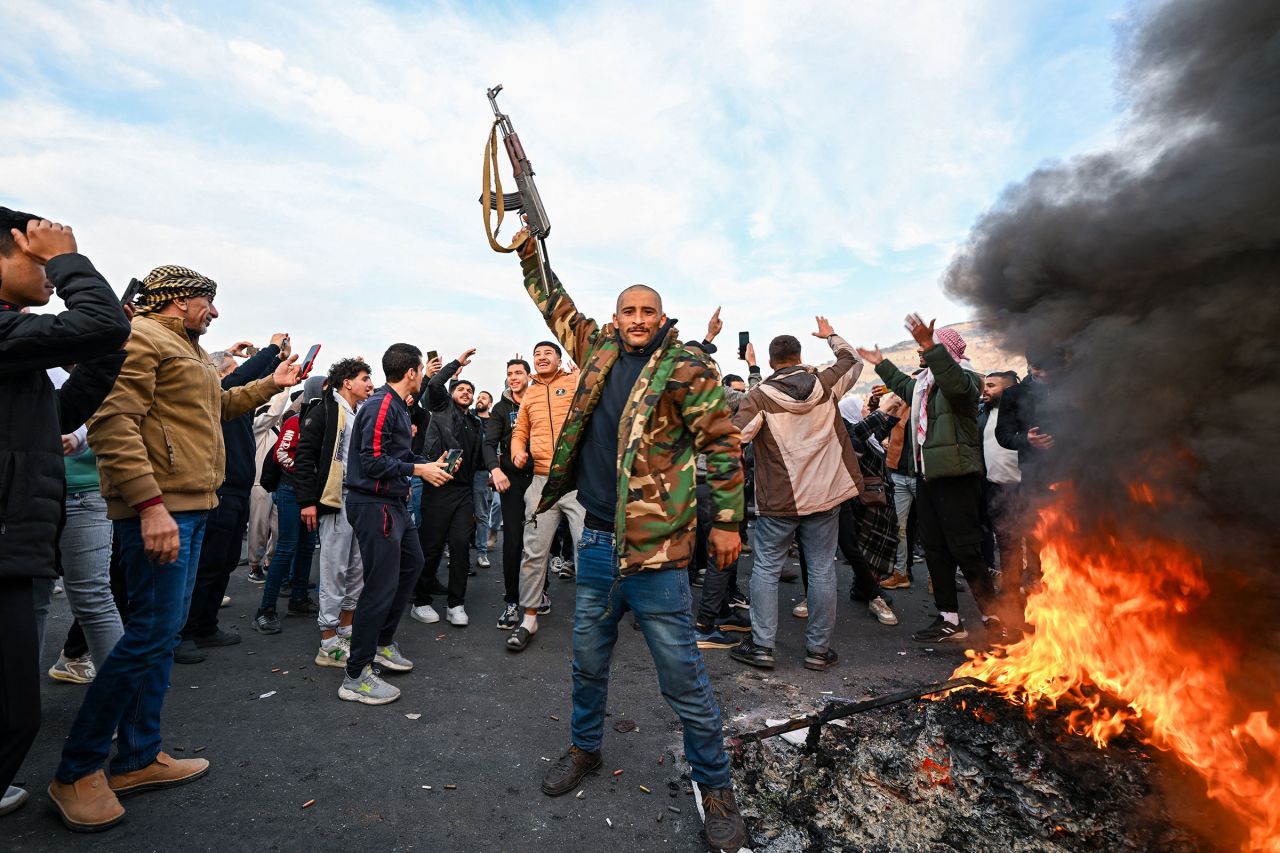 People celebrate at Umayyad Square in Damascus on December 8.