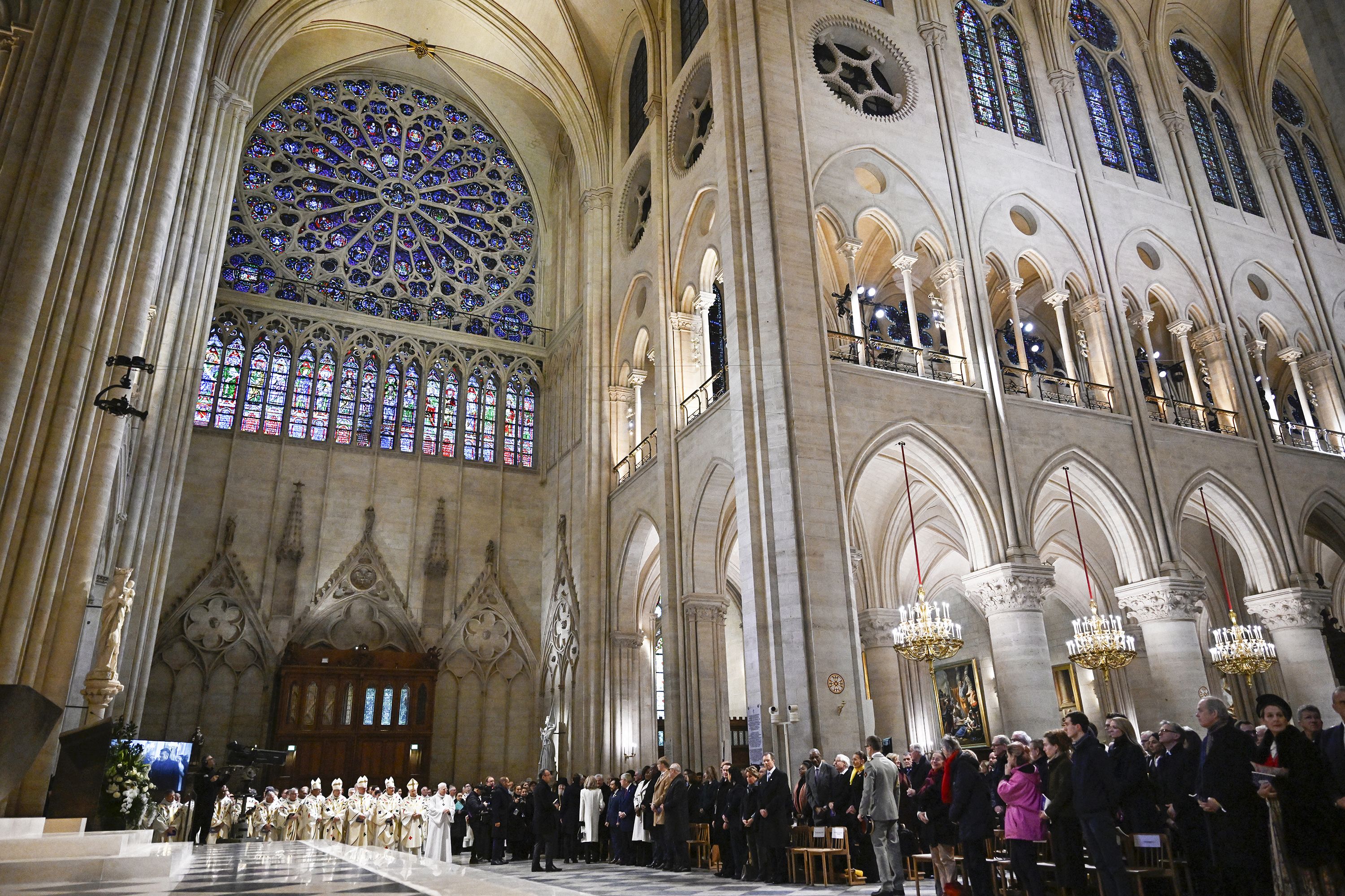 Attendees wait for the arrival of the archbishop of Paris to lead prayers for the consecration of the main altar, during the first Mass since the reconstruction of the Notre Dame cathedral, in Paris on Sunday, December 8.