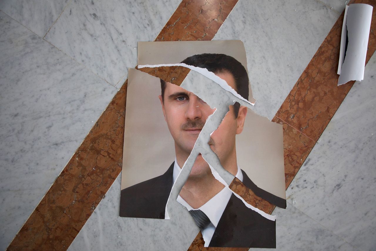 A torn portrait of Bashar al-Assad, which appears to have been arranged, is seen inside the Presidential Palace in Damascus, Syria, on December 10.