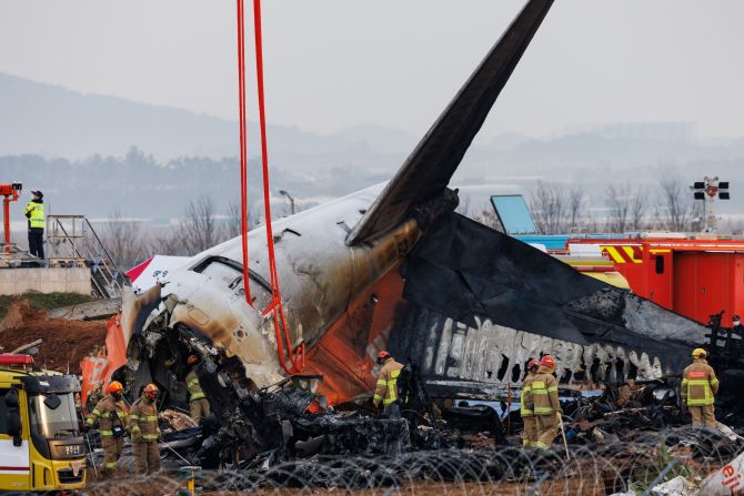 Firefighters inspect the wreckage of the crashed Jeju Air plane at Muan International Airport in Muan, South Korea, on Monday, December 30.