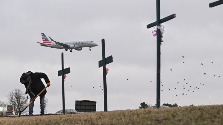 Roberto Marquez from Dallas, Texas, sets up a makeshift memorial for the victims of the deadly mid air collision near Reagan National Airport in Arlington, Virginia, on January 31.