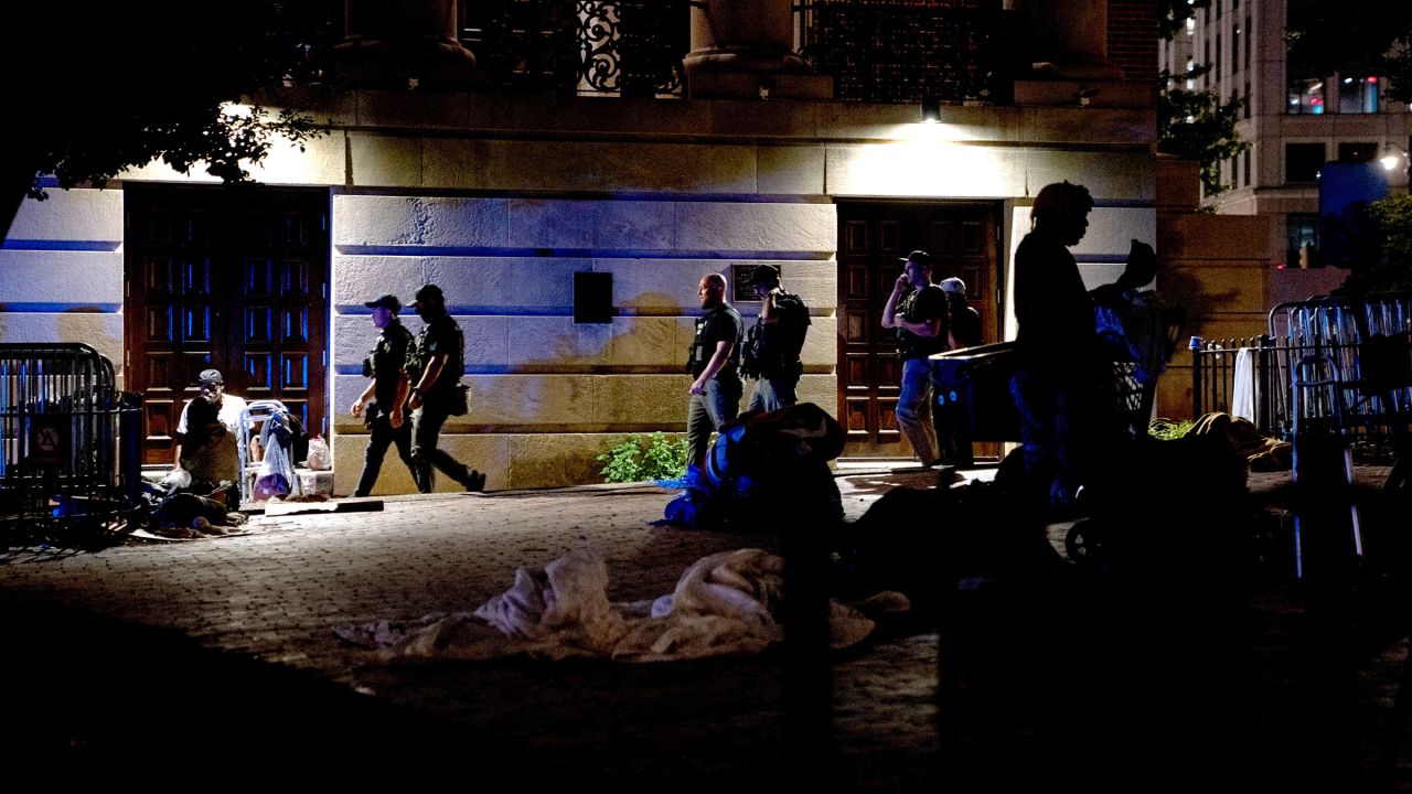 Law enforcement officers from various agencies walk near a homeless encampment in Washington, DC, on Tuesday night.