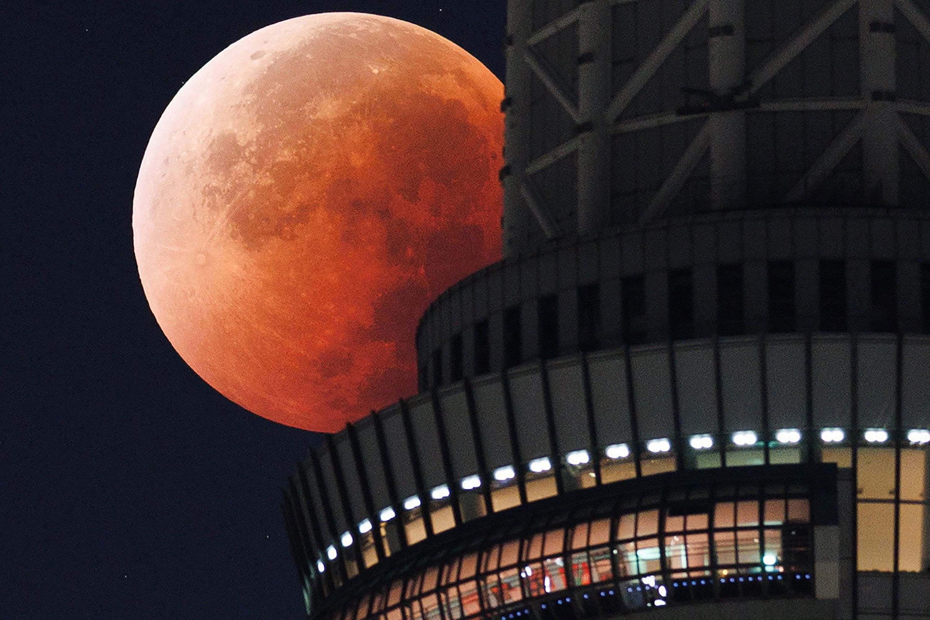 The moon appears from behind the Tokyo Skytree during a total lunar eclipse early on Monday, September 8.