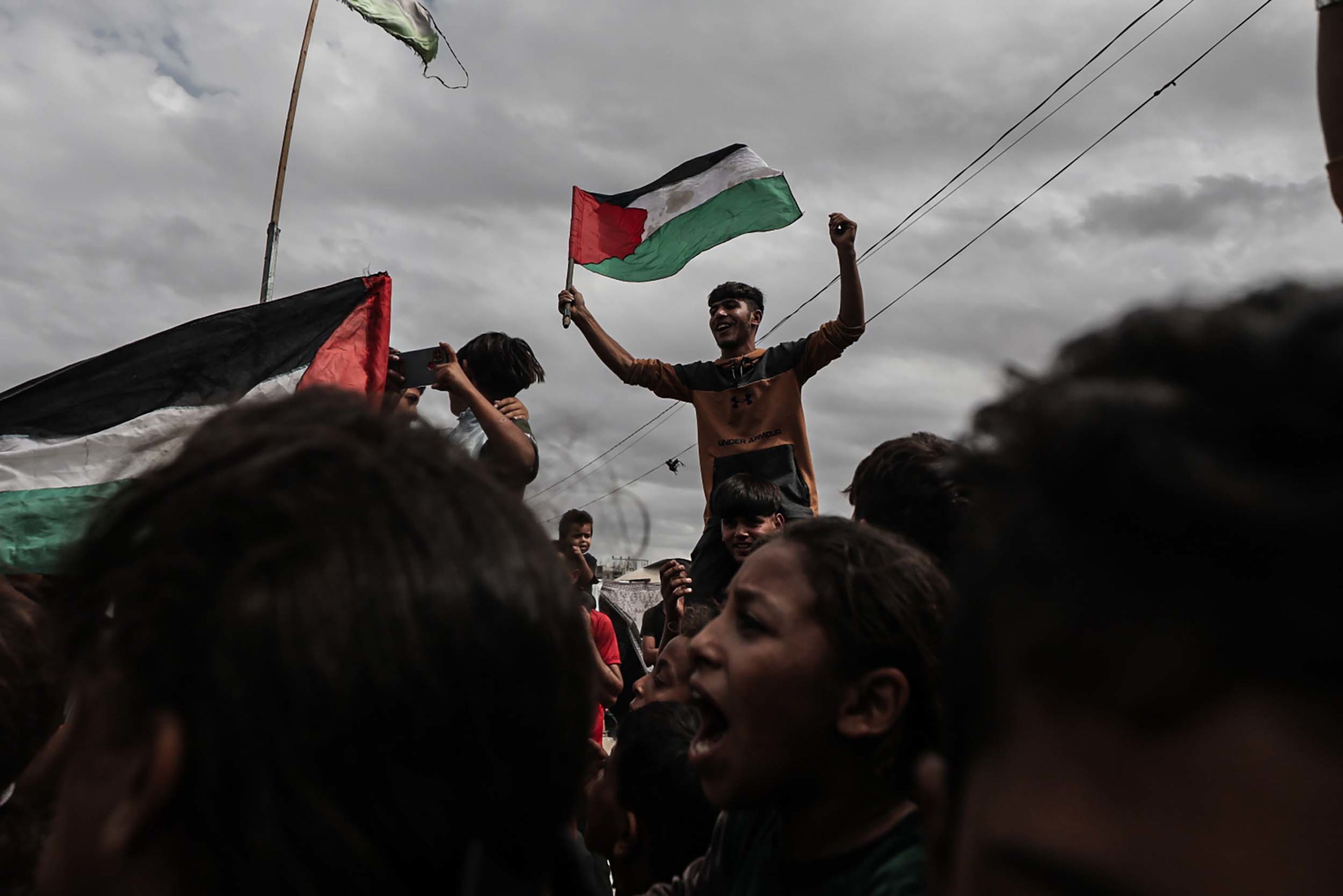 Palestinians celebrate news of a ceasefire agreement at a refugee camp in Deir-al-Balah, Gaza, on Thursday, October 9.