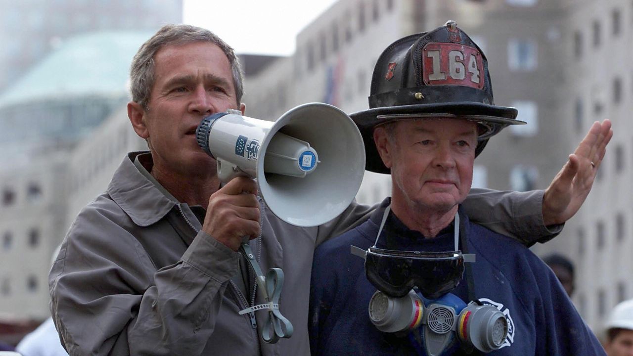 NEW YORK, NY - SEPTEMBER 14:  US President George W. Bush (L), standing next to retired firefighter Bob Beckwith, 69, speaks to volunteers and firemen as he surveys the damage at the site of the World Trade Center in New York in this 14 September 2001 file photo.  Bush was presented with the same bullhorn he used to address the rescue workers in this photo at a ceremony 25 February 2002 in the Oval Office of the White House in Washington, DC which was attended by Beckwith and New York Governor George Pataki. The President said the bullhorn would be put on display at his father's Presidential Library.  (Photo credit should read PAUL RICHARDS/AFP via Getty Images)