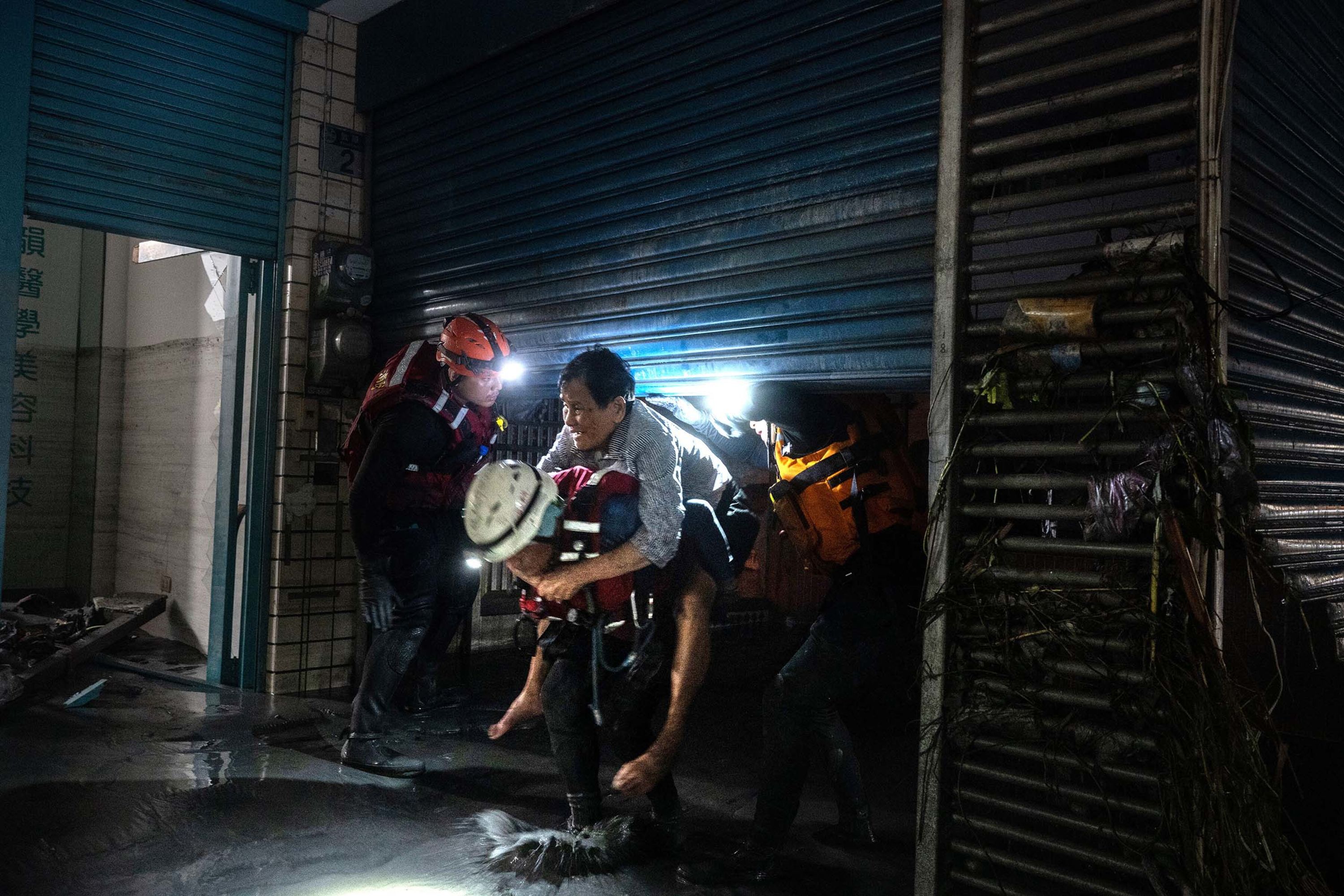 Firefighters help a man from a flooded apartment in Taiwan’s Hualien County on Wednesday, September 24.