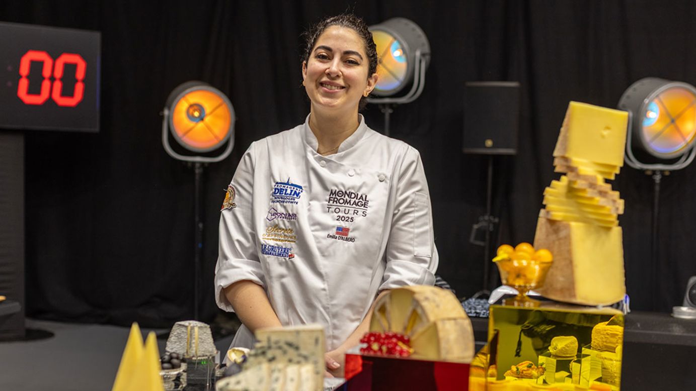 Gold medalist Emilia D'Albero poses among a sea of cheeses.