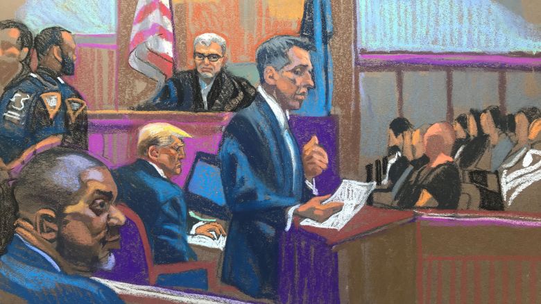 Prosecutor Matthew Colangelo speaking at the lectern Monday morning in opening statements in Day 5 of former President Donald Trump's criminal hush money trial taking place in Manhattan, NYC, April 22, 2024.<br />Manhattan District Attorney Alvin Bragg is seen in the foreground on the left, trump seated in the center of the image, with Judge Juan Merchan presiding over the trial. Jury is seen seated on the right.