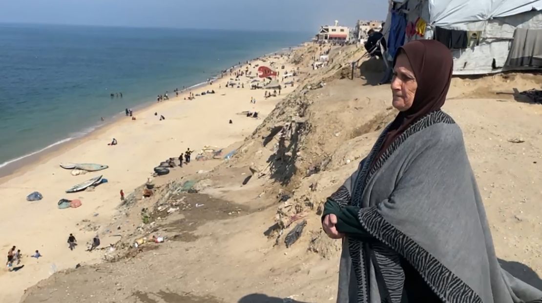 Um Ihab stands by the beach along the coast of central Gaza.