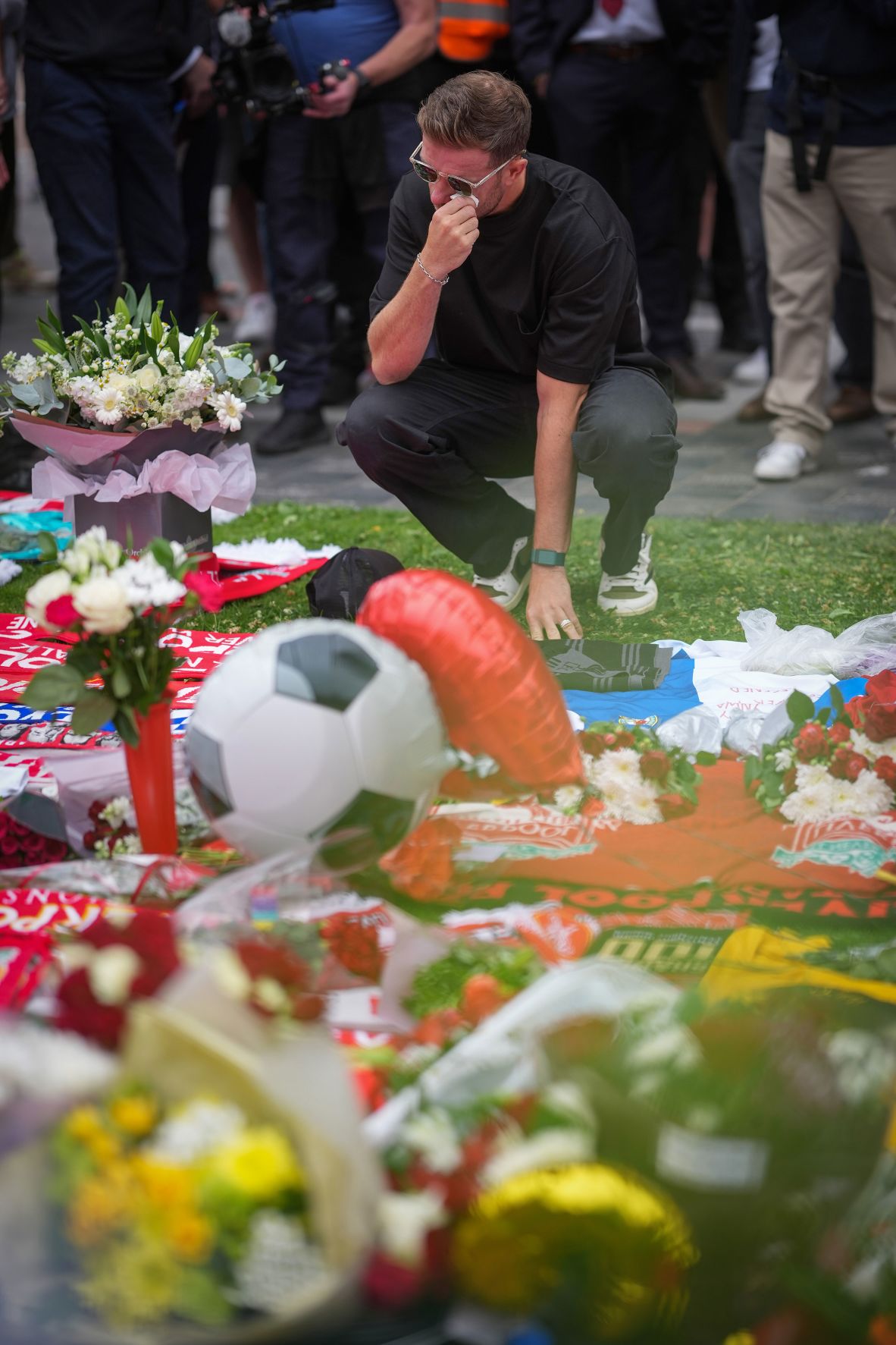 Former Liverpool captain Jordan Henderson reacts as he lays flowers at the Anfield memorial on Friday.