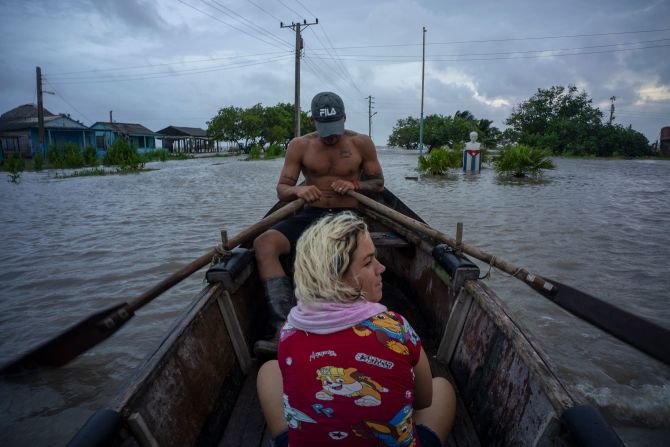 Người dân di chuyển trên thuyền qua một con phố ngập nước sau khi cơn bão Helene đi qua Guanimar, tỉnh Artemisa, Cuba, vào thứ Tư.